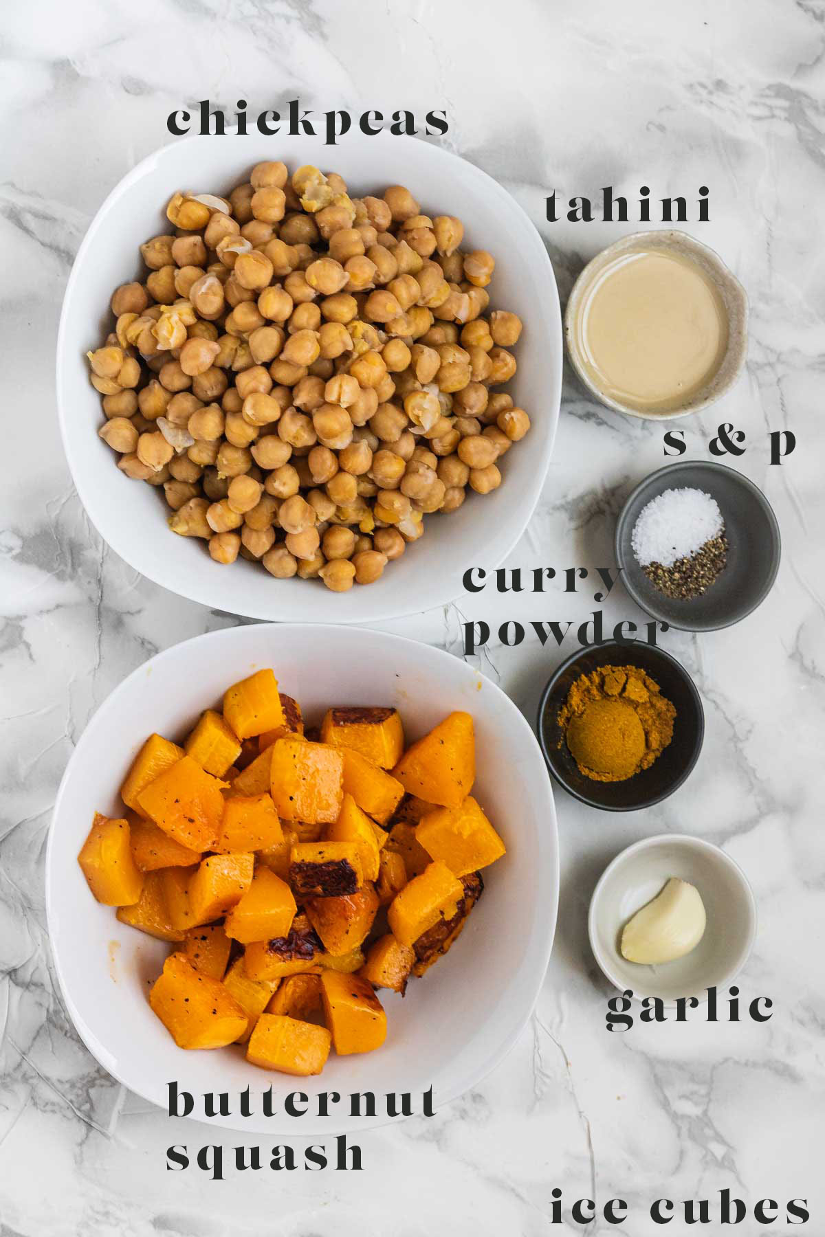 Ingredients for hummus on a white marble counter.