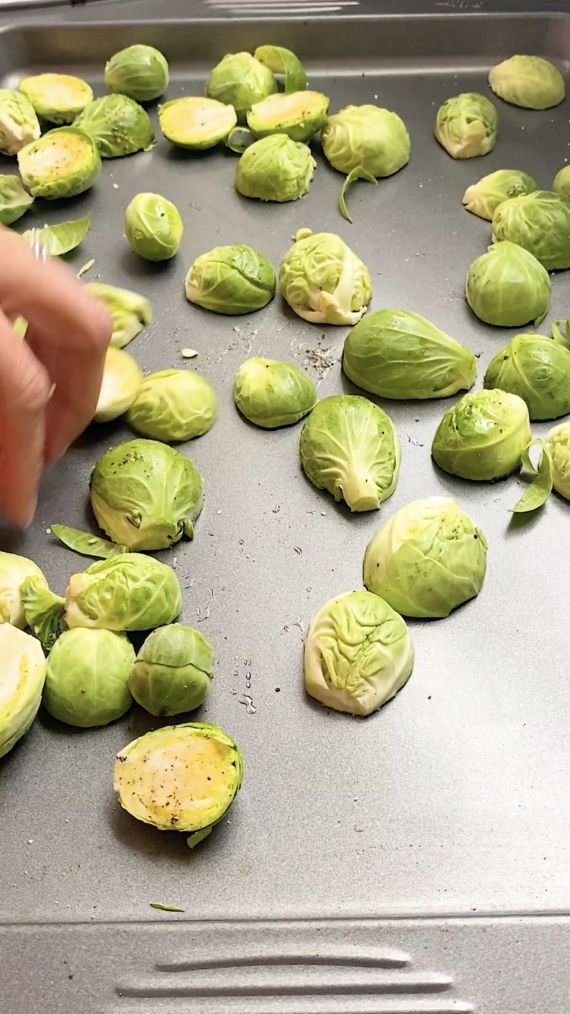 Placing halved Brussels sprouts on a baking sheet flat side down.