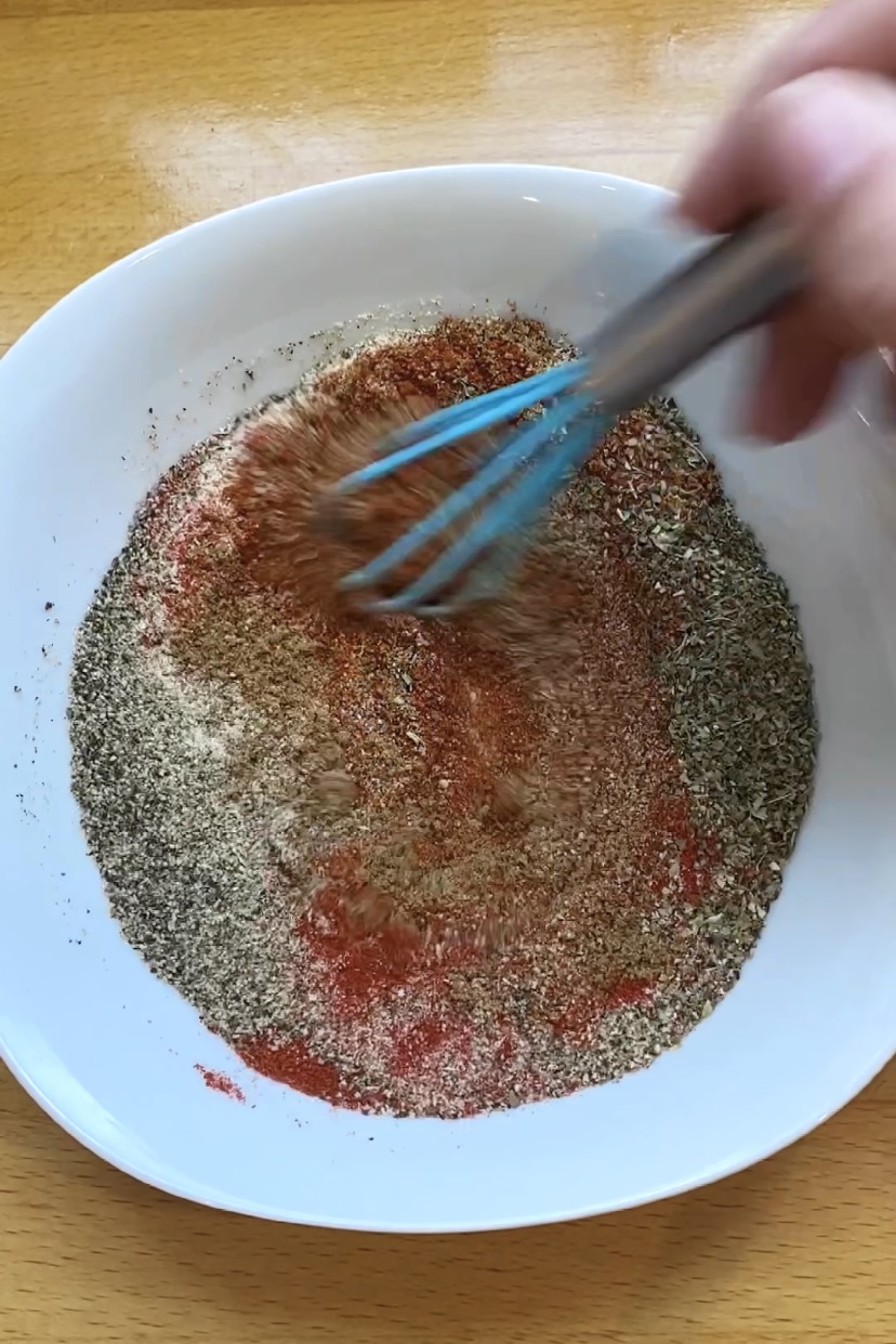 Whisking spices together in a bowl.