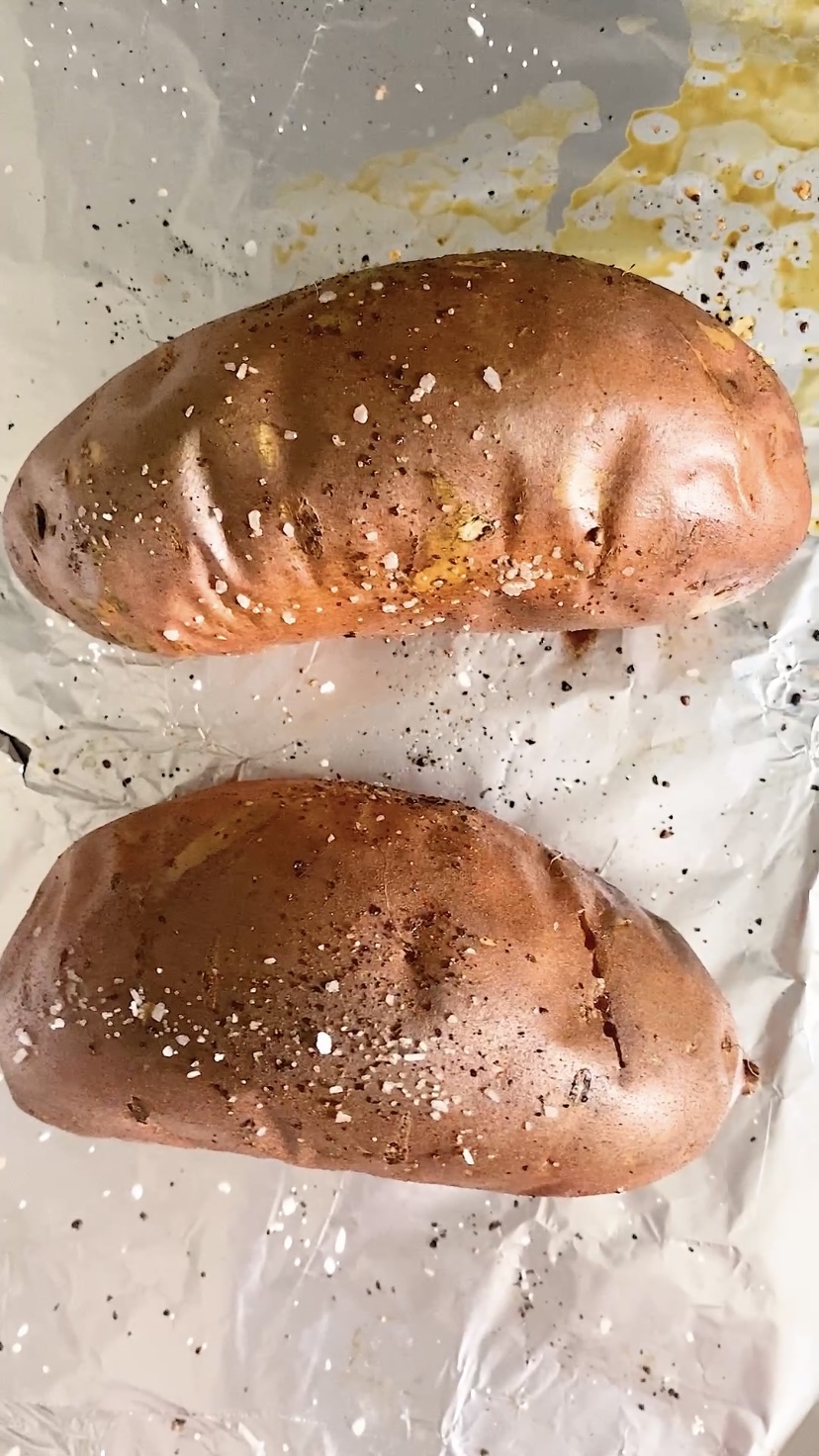 Baked sweet potatoes on a foil covered pan.