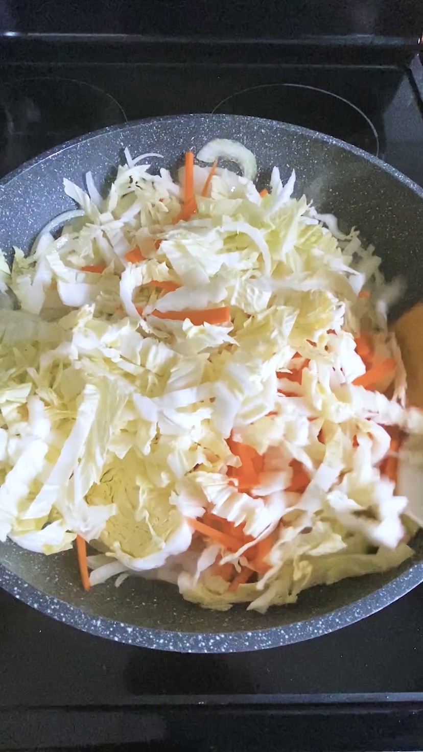 Cabbage is cooked in a large skillet.