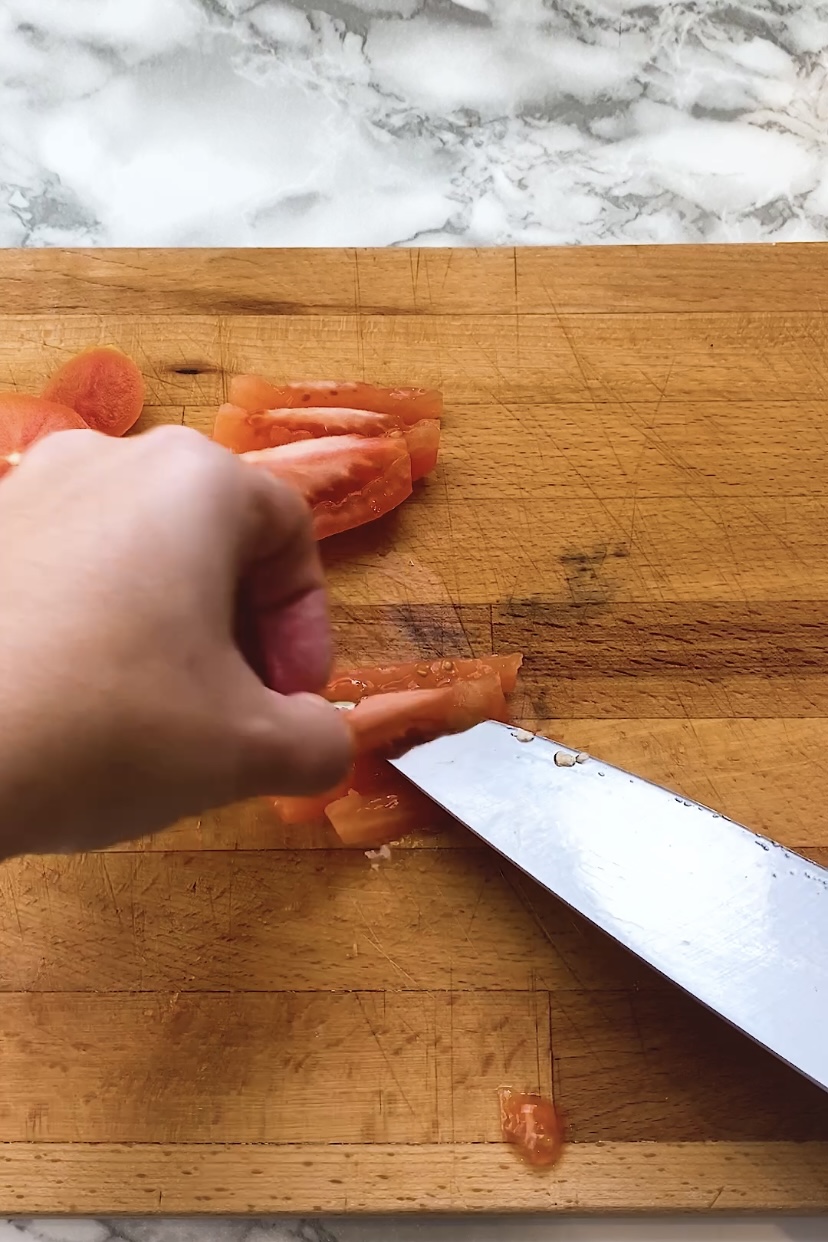 A knife is used to cut a tomato.