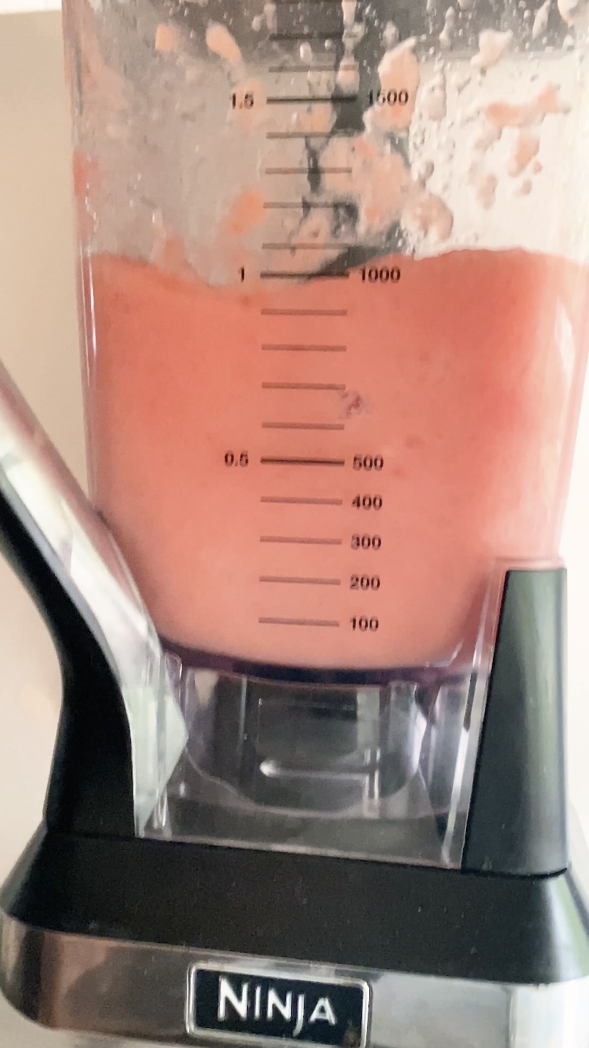 Blending a pink margarita in a blender,