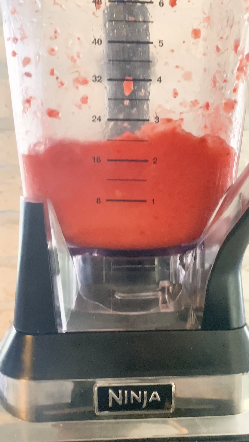 A pinky red margarita in a blender.