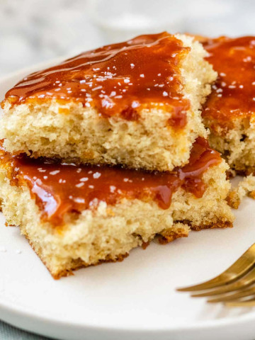 Cake on a plate with caramel sauce on top.