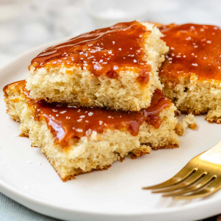 Cake on a plate with caramel sauce on top.
