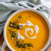 A bowl of soup with a heart shaped coconut milk swirl and seeds on top with text for Pinterest.