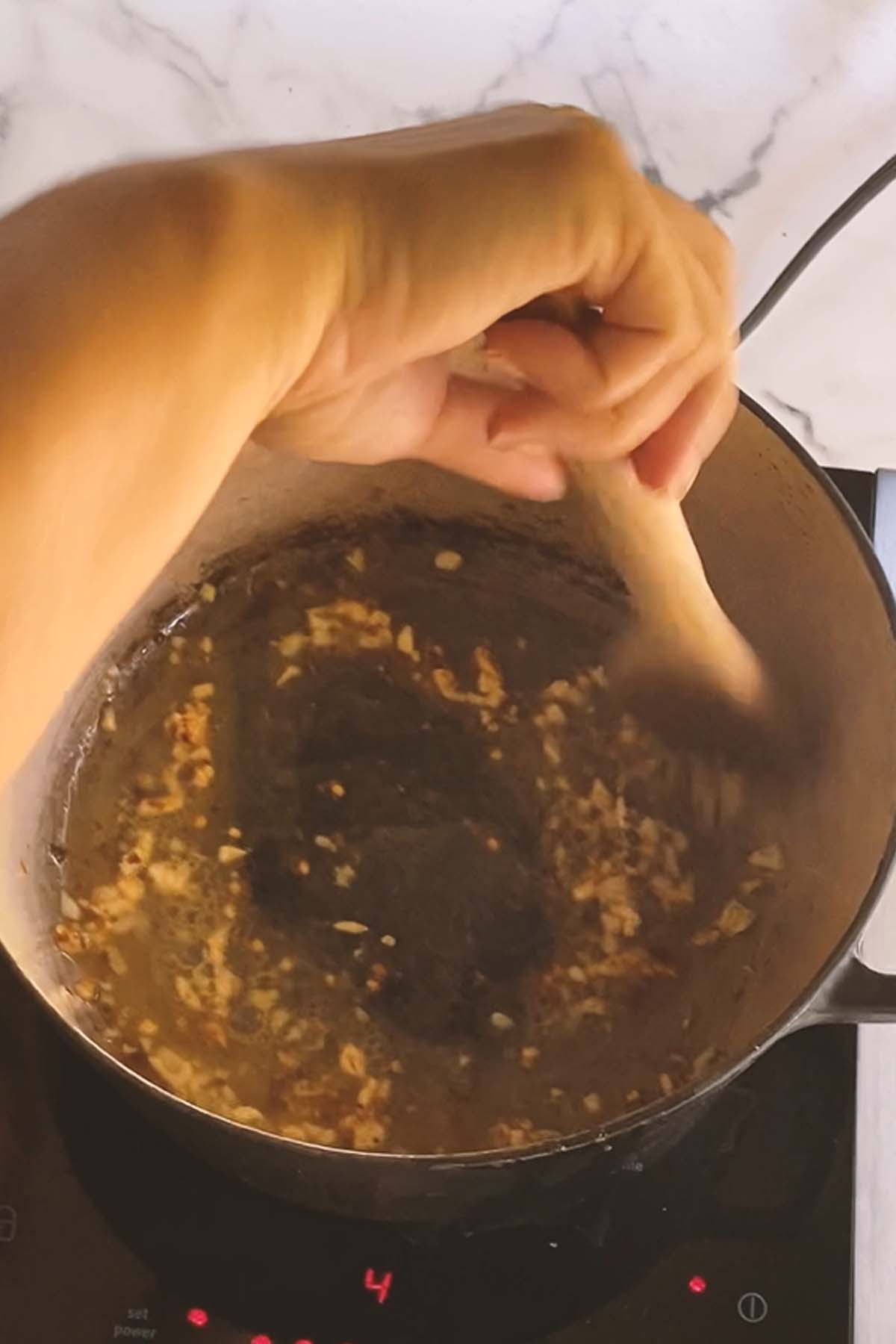 Garlic is stirred in a pot.