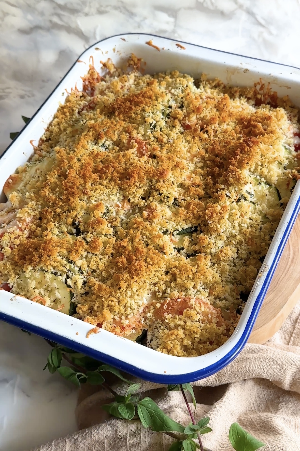 A baked casserole in a baking dish topped with browned bread crumbs.