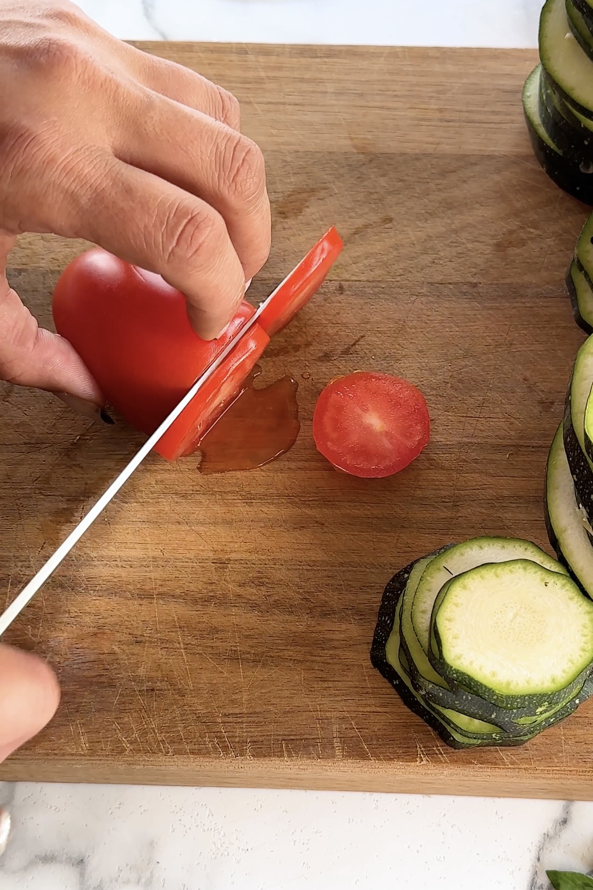 A knife slices a tomato.