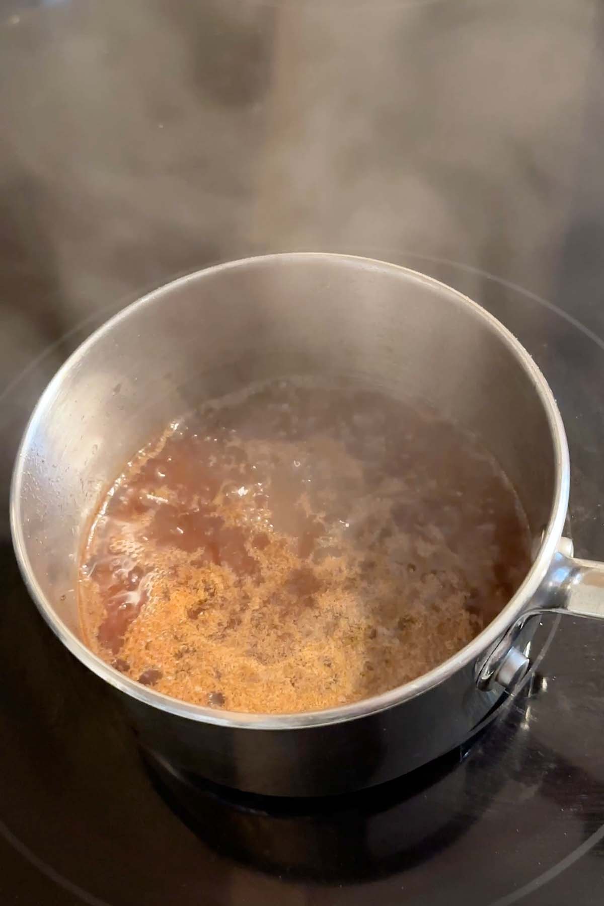 Syrup boils in a small pot.