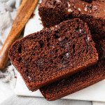 A chocolate loaf cake with slices cut.