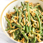 Green beans in a bowl with almonds and parmesan cheese.