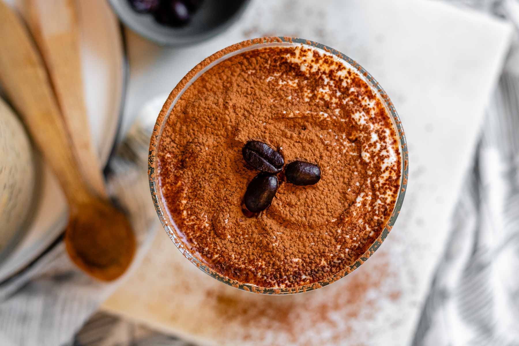Overnight oats in a glass topped with cocoa powder and 3 coffee beans.