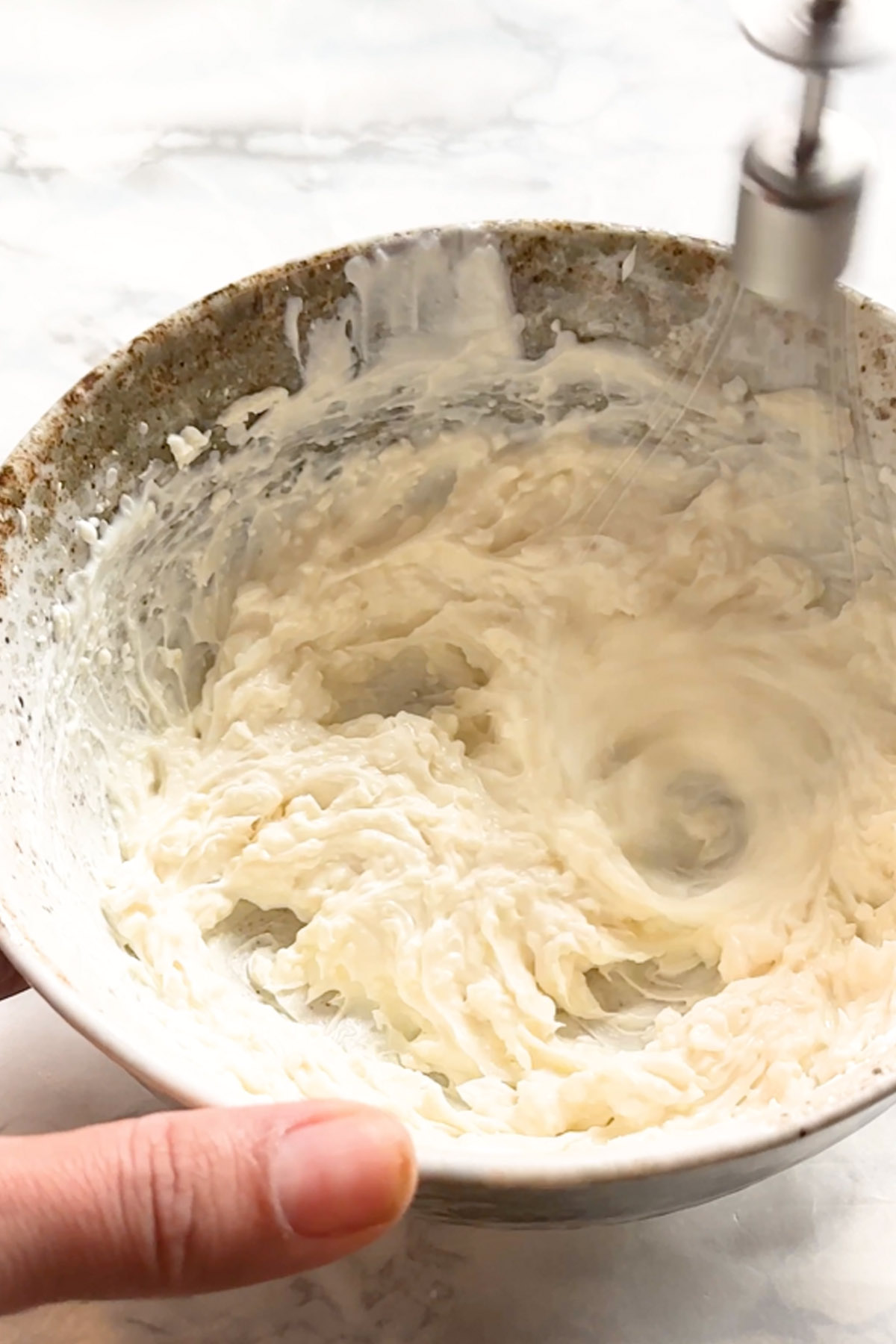 Cream cheese is whipped in bowl.