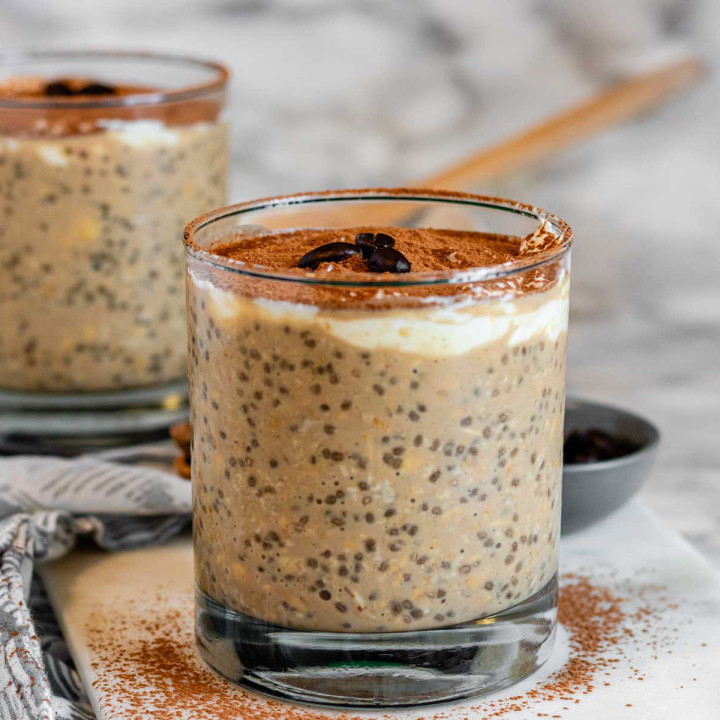 Overnight oats in a glass topped with cocoa powder and 3 coffee beans.