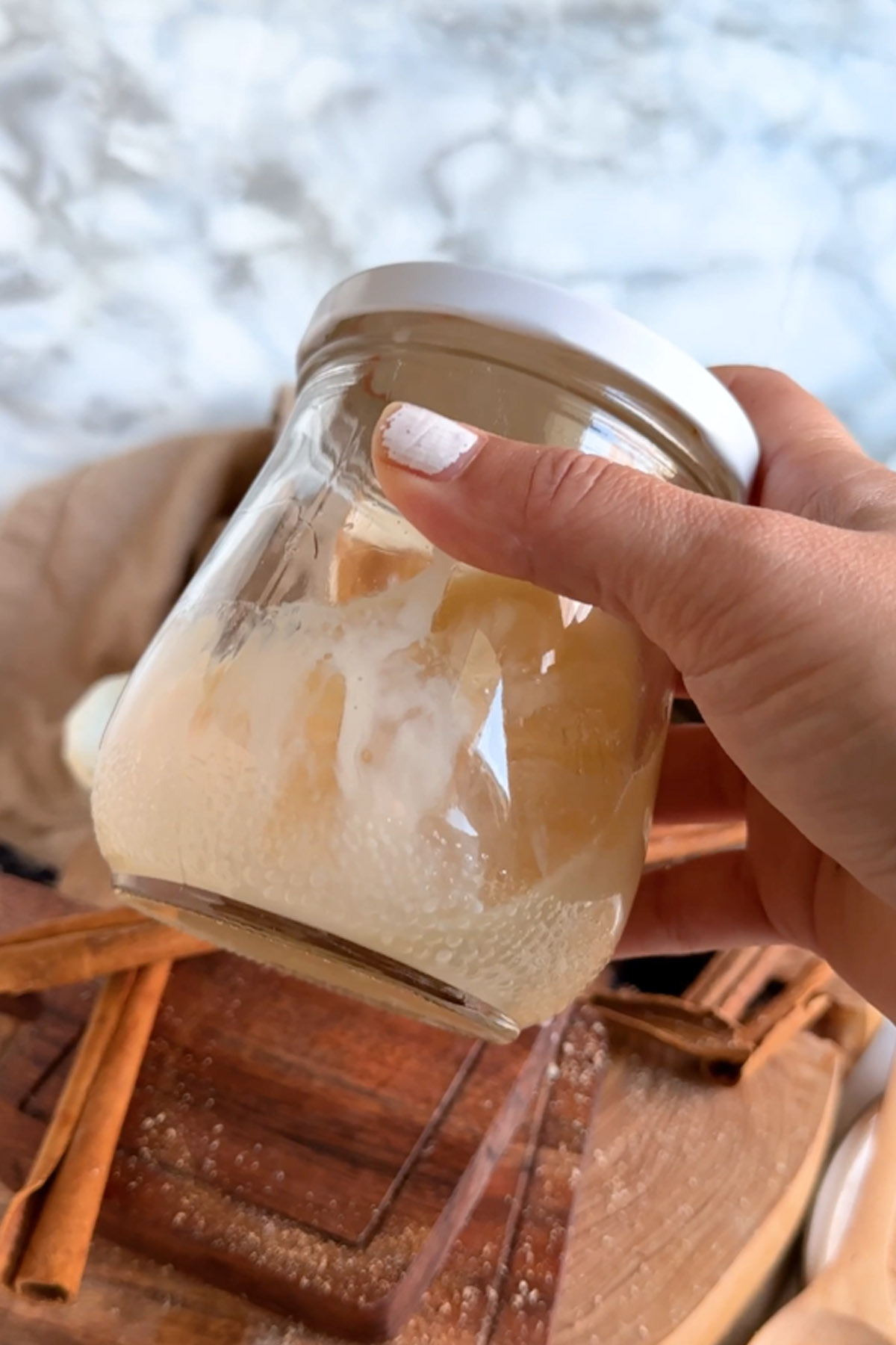 Eggnog and bourbon are shaken together in a glass jar with a lid.