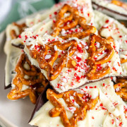 White chocolate bark topped with pretzels and candy canes on a plate.