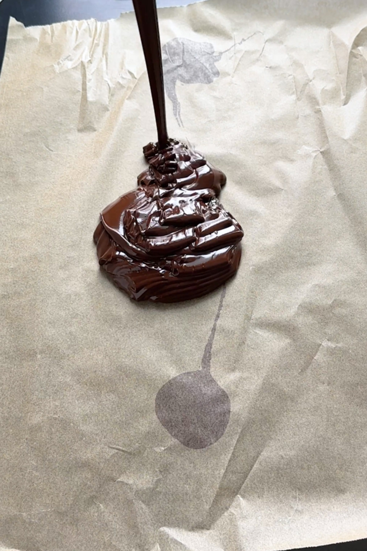 Chocolate is poured onto parchment paper.