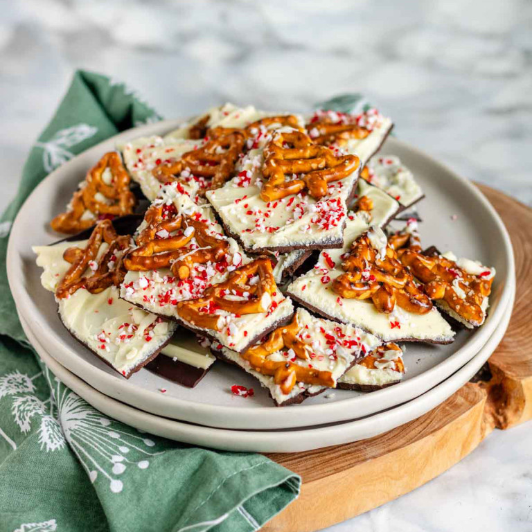 White chocolate bark topped with pretzels and candy canes on a plate.