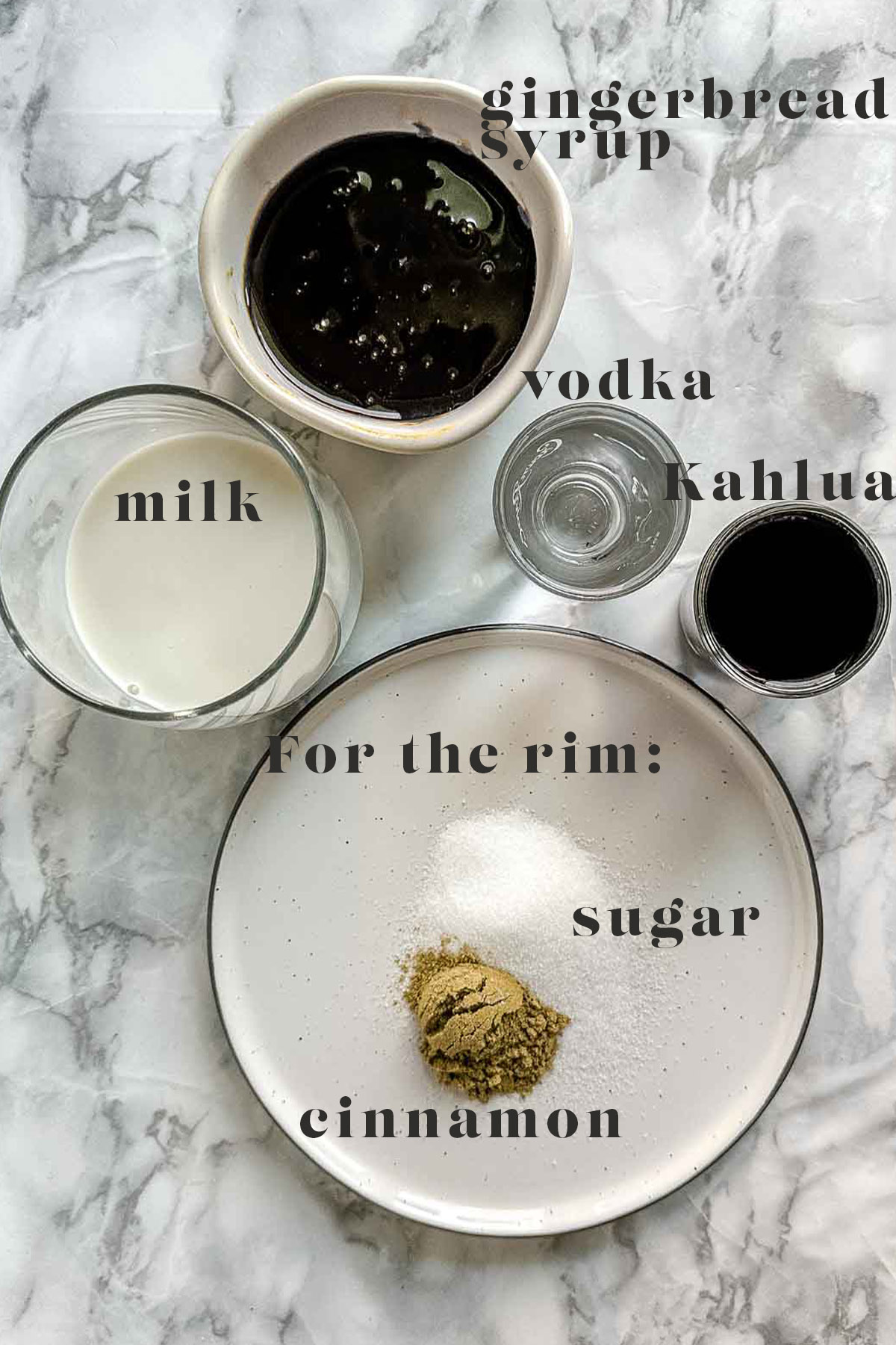 Ingredients to make a gingerbread white Russian on a white marble counter.