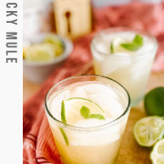 A cocktail in a glass garnished with lime and mint with text title for Pinterest.