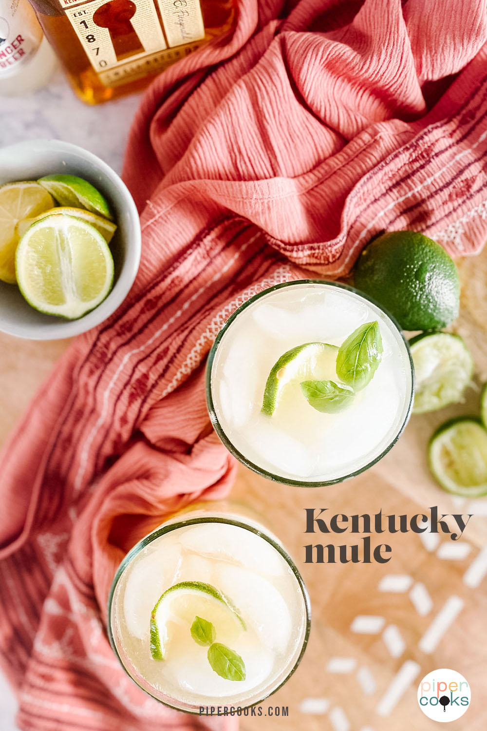 A cocktail in a glass garnished with lime and mint with text title for Pinterest.
