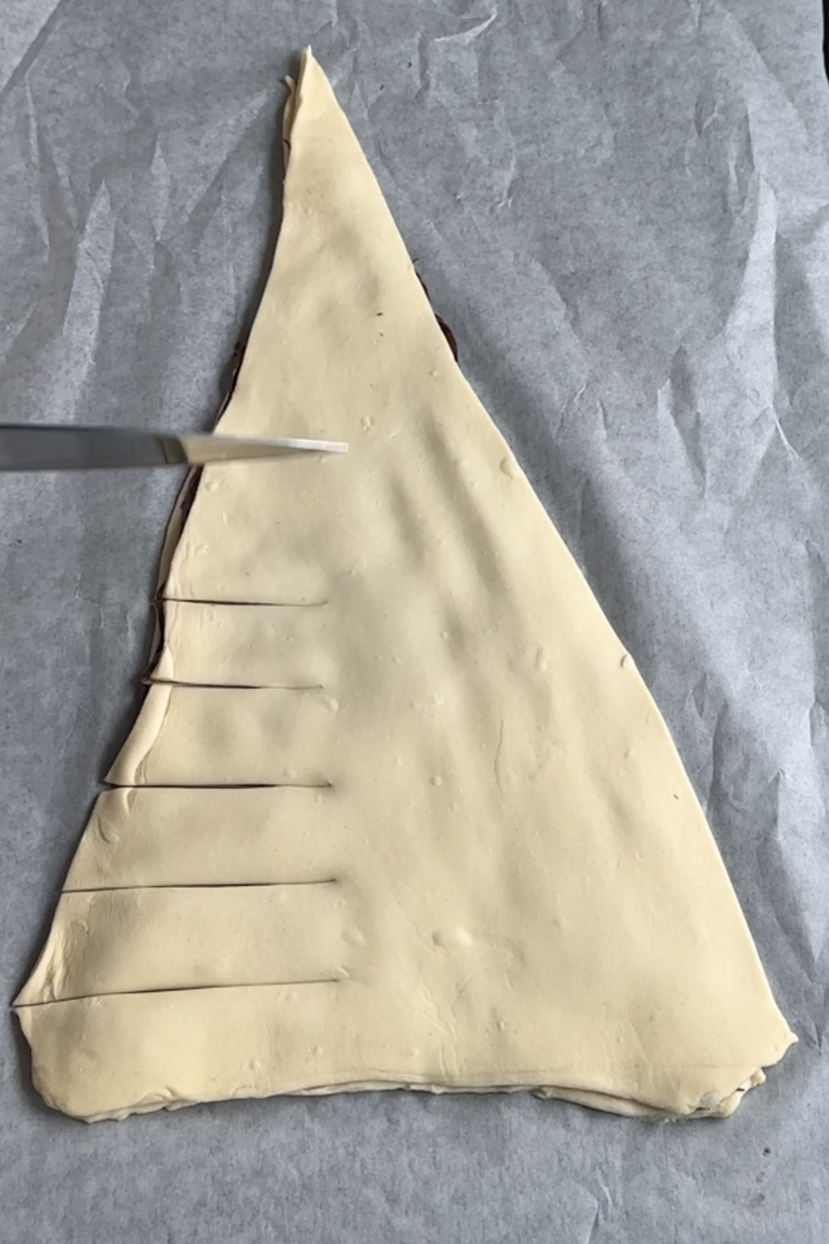 Branches are cut into a triangle of puff pastry for a tree-shaped dessert.