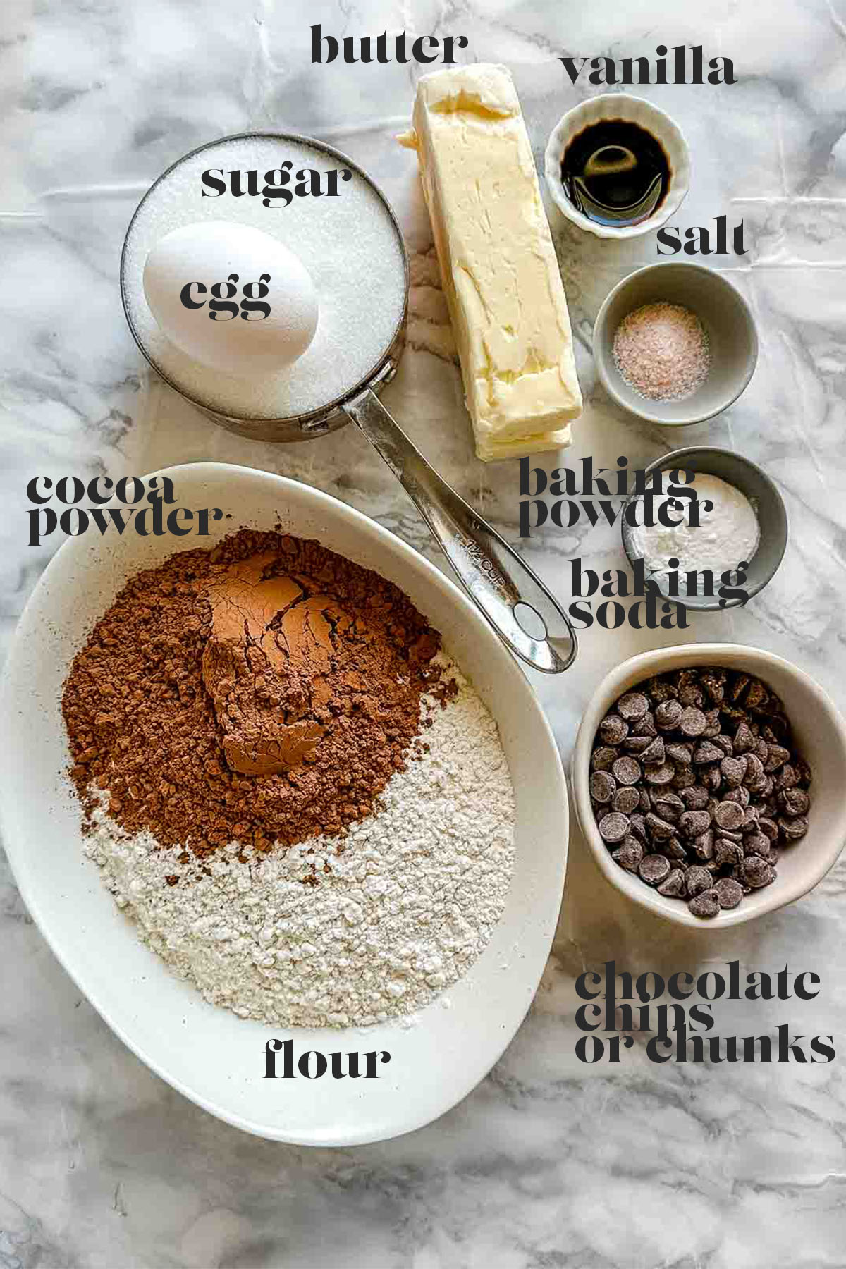 Labeled ingredients for Nutella stuffed cookies sit on a white marble counter.