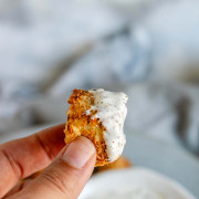 A hand holding a piece of breaded halloumi with text for Pinterest.