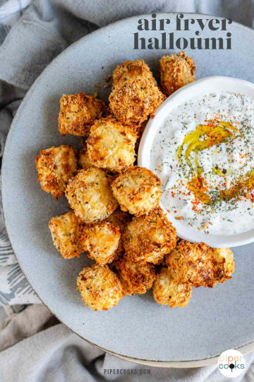 Breaded halloumi cubes on a plate with a bowl of dip with text for Pinterest.