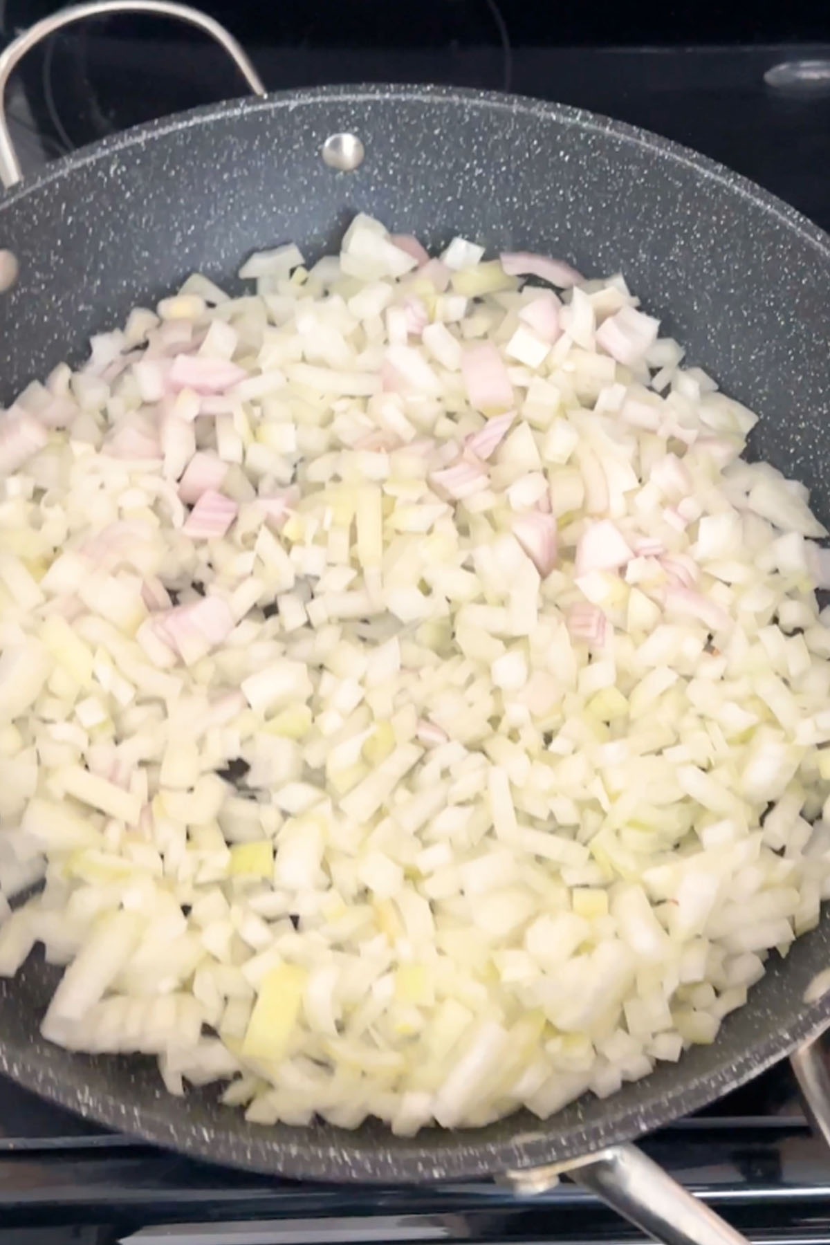 Onions cook in a skillet.