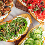 4 slices of cottage cheese toast with different toppings like avocado, cucumber, tomato, and figs.
