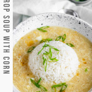 Egg drop soup in a bowl with a rounded ball of rice in the center and green onions on top with a text title for Pinterest.