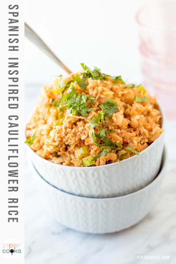Orange cauliflower rice in two stacked white bowls with text for Pinterest.