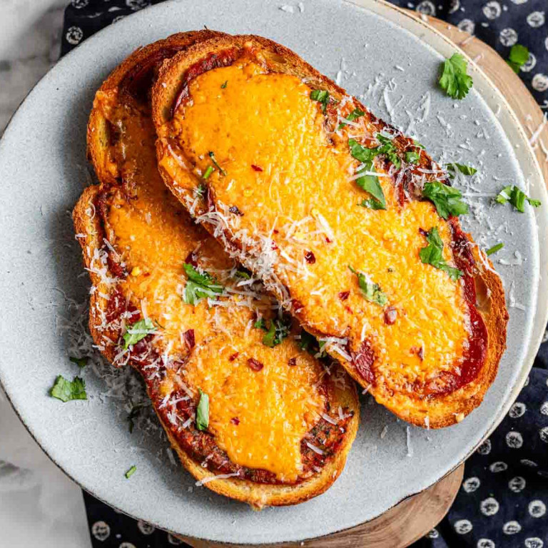 Toast with pizza toppings on it on a plate.