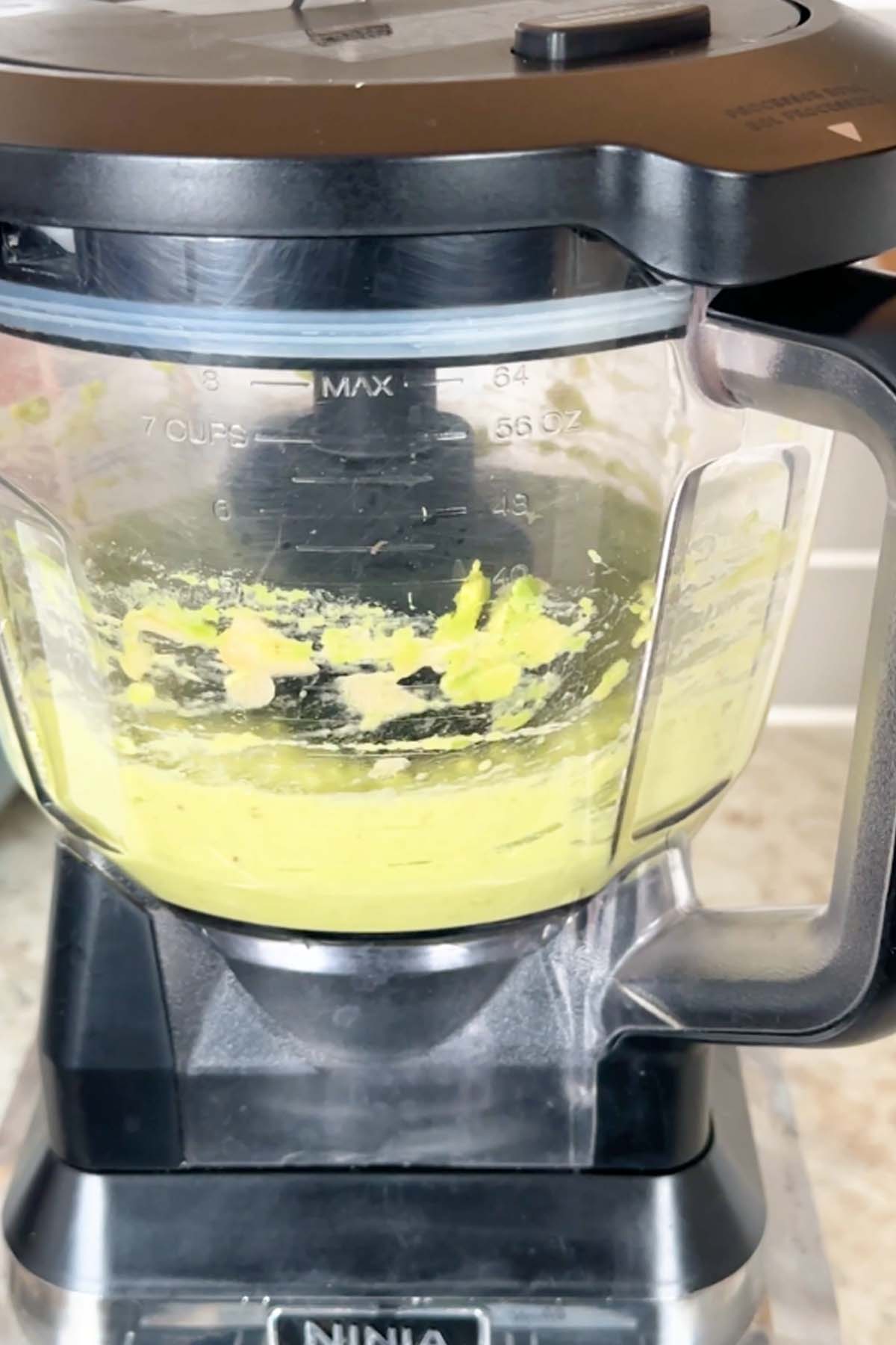 Avocado and banana are blended in a food processor.