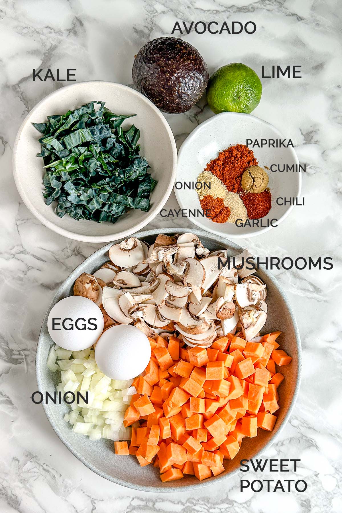 Ingredients for a sweet potato breakfast skillet on a white marble counter.