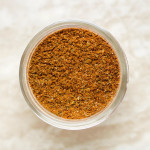 A jar with an orange seasoning mix.