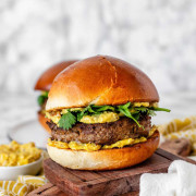 A burger with yellow sauce and cilantro leaves with the text 'curry burgers'.