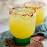 A yellow cocktail in chili powder rimmed glasses.