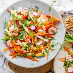 Sliced vegetables on plates topped with fresh herbs and a fork.