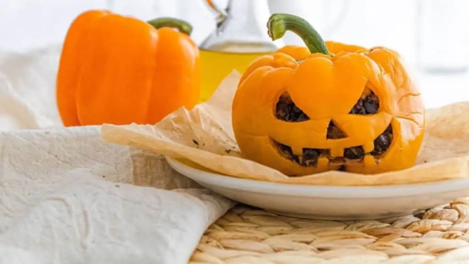An orange stuffed bell pepper cut like a jack o lantern.