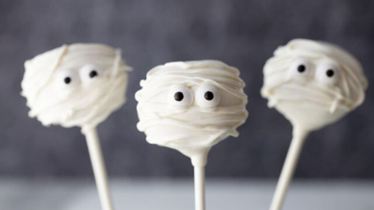 Cake pops decorated to look like mummies for Halloween.
