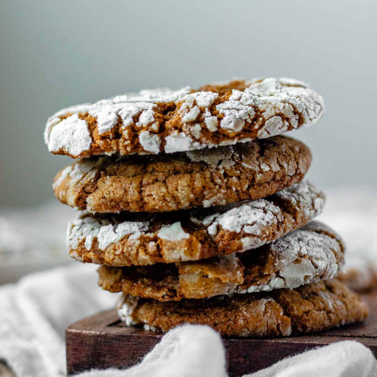 Gingerbread cookies with a crinkly top coated in powdered sugar.