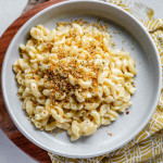 Macaroni and cheese on a plate topped with crispy breadcrumbs.