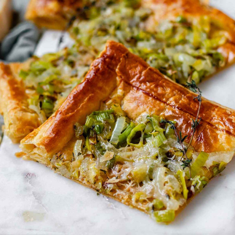 Squares of puff pastry topped with fried leeks and melted cheese.