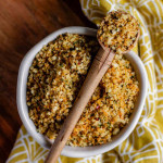 Browned panko breadcrumbs in a bowl with a spoon of breadcrumbs resting over the top.