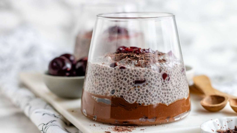 A chocolate pudding and chia pudding parfait in a glass.