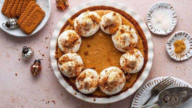 A gingerbread pie topped with chipped cream rosettes and cookie crumbs.